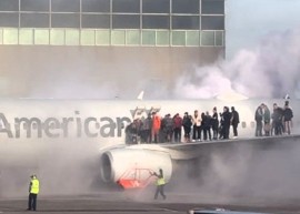 Aereo American Airlines in un aeroporto affollato prende fuoco mentre i passeggeri vengono evacuati sull'ala